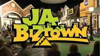 Photo of JA Biztown storefront set, overlaid by the Biztown logo